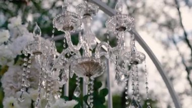 Cam bir avize ve güneş ışığında parlayan kristal bir avize. Güzel yansımalar ve ışınlar, bir ışık oyunu. Tören için düğün kemeri dekoru.