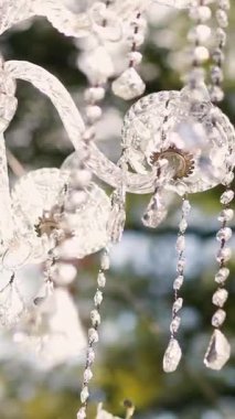 Cam bir avize ve güneş ışığında parlayan kristal bir avize. Güzel yansımalar ve ışınlar, bir ışık oyunu. Tören için düğün kemeri dekoru.