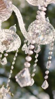 Cam bir avize ve güneş ışığında parlayan kristal bir avize. Güzel yansımalar ve ışınlar, bir ışık oyunu. Tören için düğün kemeri dekoru.