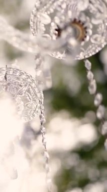 Cam bir avize ve güneş ışığında parlayan kristal bir avize. Güzel yansımalar ve ışınlar, bir ışık oyunu. Tören için düğün kemeri dekoru.