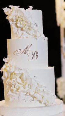 Akşam düğün kemeri beyaz çiçekler ve açık havada fenerlerle yeşillik. Resmî törende çiçek ve dekor. Kremalı büyük beyaz pasta.