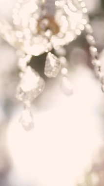 Cam bir avize ve güneş ışığında parlayan kristal bir avize. Güzel yansımalar ve ışınlar, bir ışık oyunu. Tören için düğün kemeri dekoru.