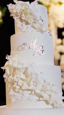 Akşam düğün kemeri beyaz çiçekler ve açık havada fenerlerle yeşillik. Resmî törende çiçek ve dekor. Kremalı büyük beyaz pasta.