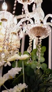 Cam bir avize ve güneş ışığında parlayan kristal bir avize. Güzel yansımalar ve ışınlar, bir ışık oyunu. Tören için düğün kemeri dekoru.