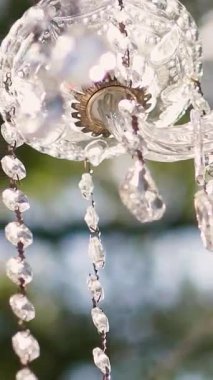Cam bir avize ve güneş ışığında parlayan kristal bir avize. Güzel yansımalar ve ışınlar, bir ışık oyunu. Tören için düğün kemeri dekoru.