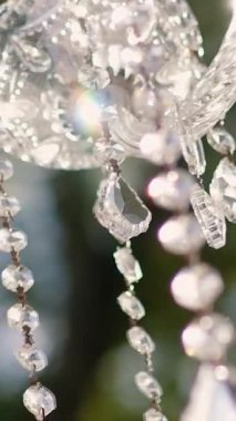 Cam bir avize ve güneş ışığında parlayan kristal bir avize. Güzel yansımalar ve ışınlar, bir ışık oyunu. Tören için düğün kemeri dekoru.