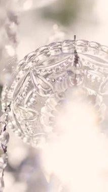 Cam bir avize ve güneş ışığında parlayan kristal bir avize. Güzel yansımalar ve ışınlar, bir ışık oyunu. Tören için düğün kemeri dekoru.