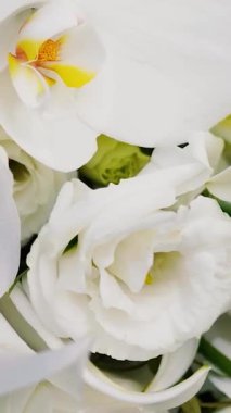 Düğünden önceki gün, güzel ve güzel kokulu bir buket beyaz gül ve zambak. Aşkın sembolü olarak alyansların yakın plan çekimi..