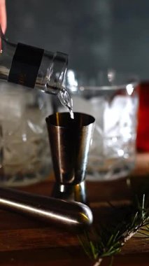 Cin tonik ve bardaklarda buzla yapılan nefis alkollü kokteyl geceleri dinlenmek ve yazın ferahlatıcı olmak için. Baharat ve aroma için yeşil limon. Barmen ve bar. Biberiye ateşle yanıyor.