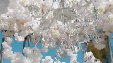 Cam bir avize ve güneş ışığında parlayan kristal bir avize. Güzel yansımalar ve ışınlar, bir ışık oyunu. Tören için düğün kemeri dekoru..