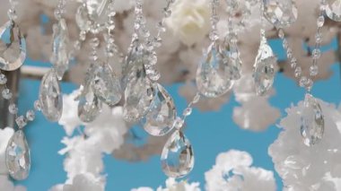 Cam bir avize ve güneş ışığında parlayan kristal bir avize. Güzel yansımalar ve ışınlar, bir ışık oyunu. Tören için düğün kemeri dekoru..