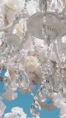 Cam bir avize ve güneş ışığında parlayan kristal bir avize. Güzel yansımalar ve ışınlar, bir ışık oyunu. Tören için düğün kemeri dekoru..