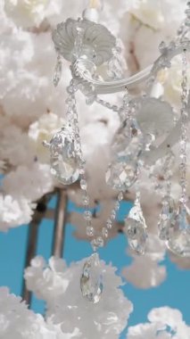 Cam bir avize ve güneş ışığında parlayan kristal bir avize. Güzel yansımalar ve ışınlar, bir ışık oyunu. Tören için düğün kemeri dekoru..