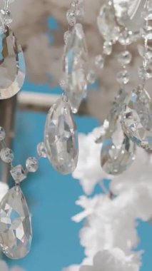 Cam bir avize ve güneş ışığında parlayan kristal bir avize. Güzel yansımalar ve ışınlar, bir ışık oyunu. Tören için düğün kemeri dekoru..