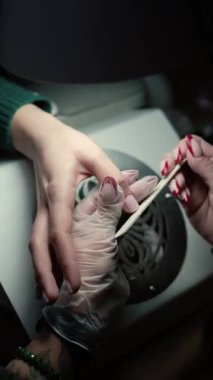 Güzellik ustası manikürcü, güzellik salonunda genç ve güzel bir kıza el ve parmaklarıyla manikür yapıyor. Tamirci aletlerini kapat