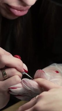 Güzellik ustası manikürcü, güzellik salonunda genç ve güzel bir kıza el ve parmaklarıyla manikür yapıyor. Tamirci aletlerini kapat