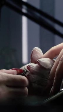 Güzellik ustası manikürcü, güzellik salonunda genç ve güzel bir kıza el ve parmaklarıyla manikür yapıyor. Tamirci aletlerini kapat