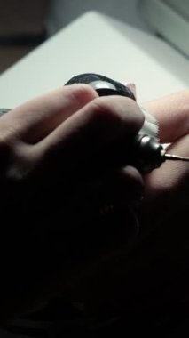 Güzellik ustası manikürcü, güzellik salonunda genç ve güzel bir kıza el ve parmaklarıyla manikür yapıyor. Tamirci aletlerini kapat