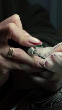 Güzellik ustası manikürcü, güzellik salonunda genç ve güzel bir kıza el ve parmaklarıyla manikür yapıyor. Tamirci aletlerini kapat