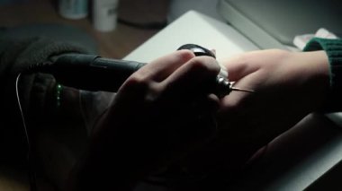 Güzellik ustası manikürcü, güzellik salonunda genç ve güzel bir kıza el ve parmaklarıyla manikür yapıyor. Tamirci aletlerini kapat