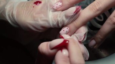 Güzellik ustası manikürcü, güzellik salonunda genç ve güzel bir kıza el ve parmaklarıyla manikür yapıyor. Tamirci aletlerini kapat