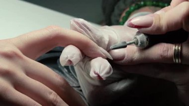 Güzellik ustası manikürcü, güzellik salonunda genç ve güzel bir kıza el ve parmaklarıyla manikür yapıyor. Tamirci aletlerini kapat
