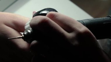 Güzellik ustası manikürcü, güzellik salonunda genç ve güzel bir kıza el ve parmaklarıyla manikür yapıyor. Tamirci aletlerini kapat