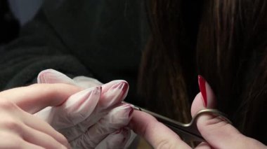 Güzellik ustası manikürcü, güzellik salonunda genç ve güzel bir kıza el ve parmaklarıyla manikür yapıyor. Tamirci aletlerini kapat