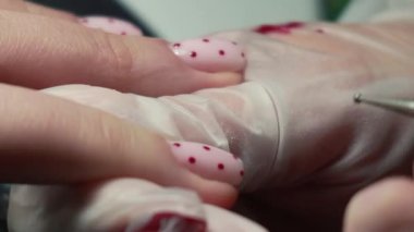 Güzellik ustası manikürcü, güzellik salonunda genç ve güzel bir kıza el ve parmaklarıyla manikür yapıyor. Tamirci aletlerini kapat