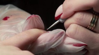 Güzellik ustası manikürcü, güzellik salonunda genç ve güzel bir kıza el ve parmaklarıyla manikür yapıyor. Tamirci aletlerini kapat