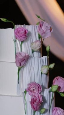 Akşam düğün kemeri beyaz çiçekler ve açık havada fenerlerle yeşillik. Resmî törende çiçek ve dekor. Kremalı büyük beyaz pasta.