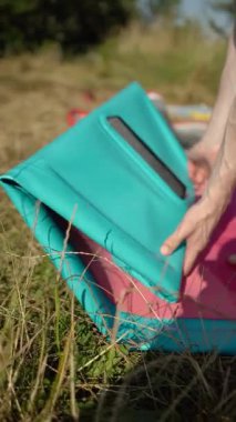 Bir sörfçü nehirde yüzmeden önce yemek tahtasını şişirir. Güneşli bir hafta sonu ve güneşli havalarda tatil aktiviteleri.