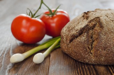 Domates ile pişmiş ekmek, soğan ahşap masa arka plan üzerinde