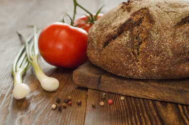 Ekmek domates, soğan ve ahşap masa arka plan üzerine biber ile