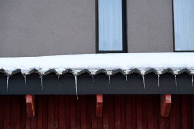 Çatı kar ve buz saçaklarıyla kaplı.