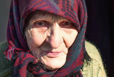 Emekli yaşlı bir kadının portresi. Doğa arka planında bir fotoğraf.