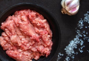 Sarımsak ve tuzlu siyah bir kasede ev yapımı kıyma. Taze çiğ. Üst görünüm.