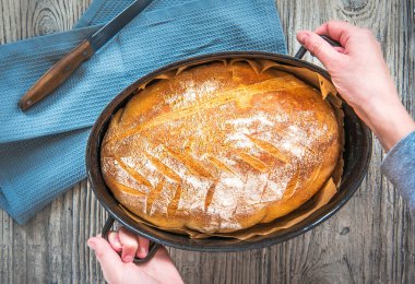 Elleri taze pişmiş bir tava taze ekmek tutuyordu.