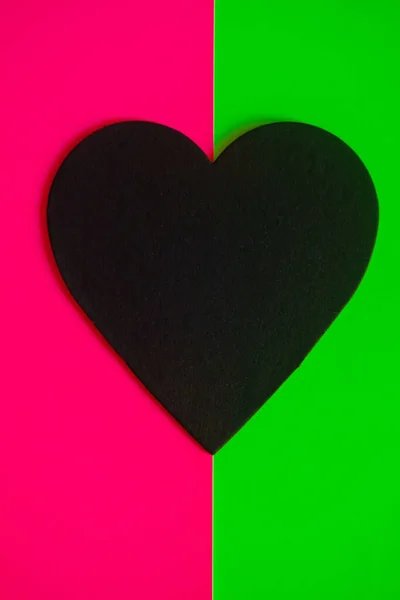 Corazón negro sobre un fondo rosa brillante y verde — Foto de Stock