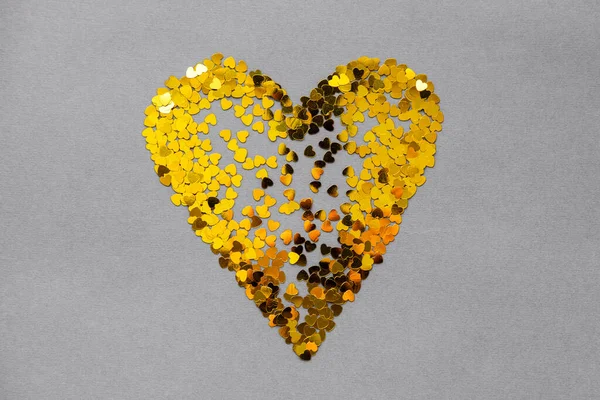 El amor es un corazón amarillo sobre un fondo gris en el Día de San Valentín — Foto de Stock