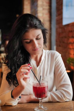 Kadın lokantada ya da kafede sıcak şarap içiyor..