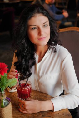 Kadın lokantada ya da kafede sıcak şarap içiyor..