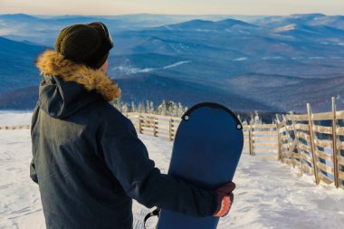 Sheregesh dağlarında başarılı bir snowboard sporcusu. Snowboardcu dağın tepesinde dinleniyor. Gökyüzünün arka planında beyaz bir snowboardcu. Snowboard takımında iş adamlarının toplantısı..