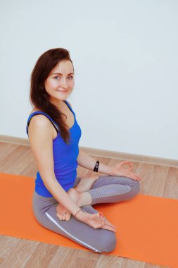 Turuncu paspasın üzerinde yoga yapan kadın, esniyor..
