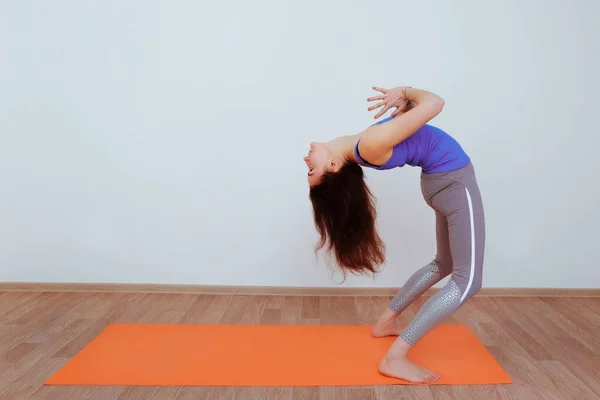 Femme Faisant Exercice Yoga Sur Tapis Orange Étirement Image En Vente