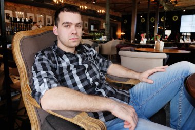 İş adamı elinde dijital tabletle bir kafede oturuyor..