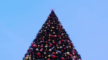 Yılbaşı çelenkleri ve Noel süsleri, kırmızı bir yıldız, sokakta balonlar.