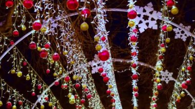 Yılbaşı çelenkleri ve Noel süsleri, kırmızı bir yıldız, sokakta balonlar.