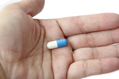 Beyaz arka plan üzerinde elinde hap kapsül 