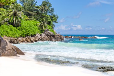 zemin kaya ve bulutlu gökyüzü karşı sahilde güzel turkuaz, masmavi dalgalar